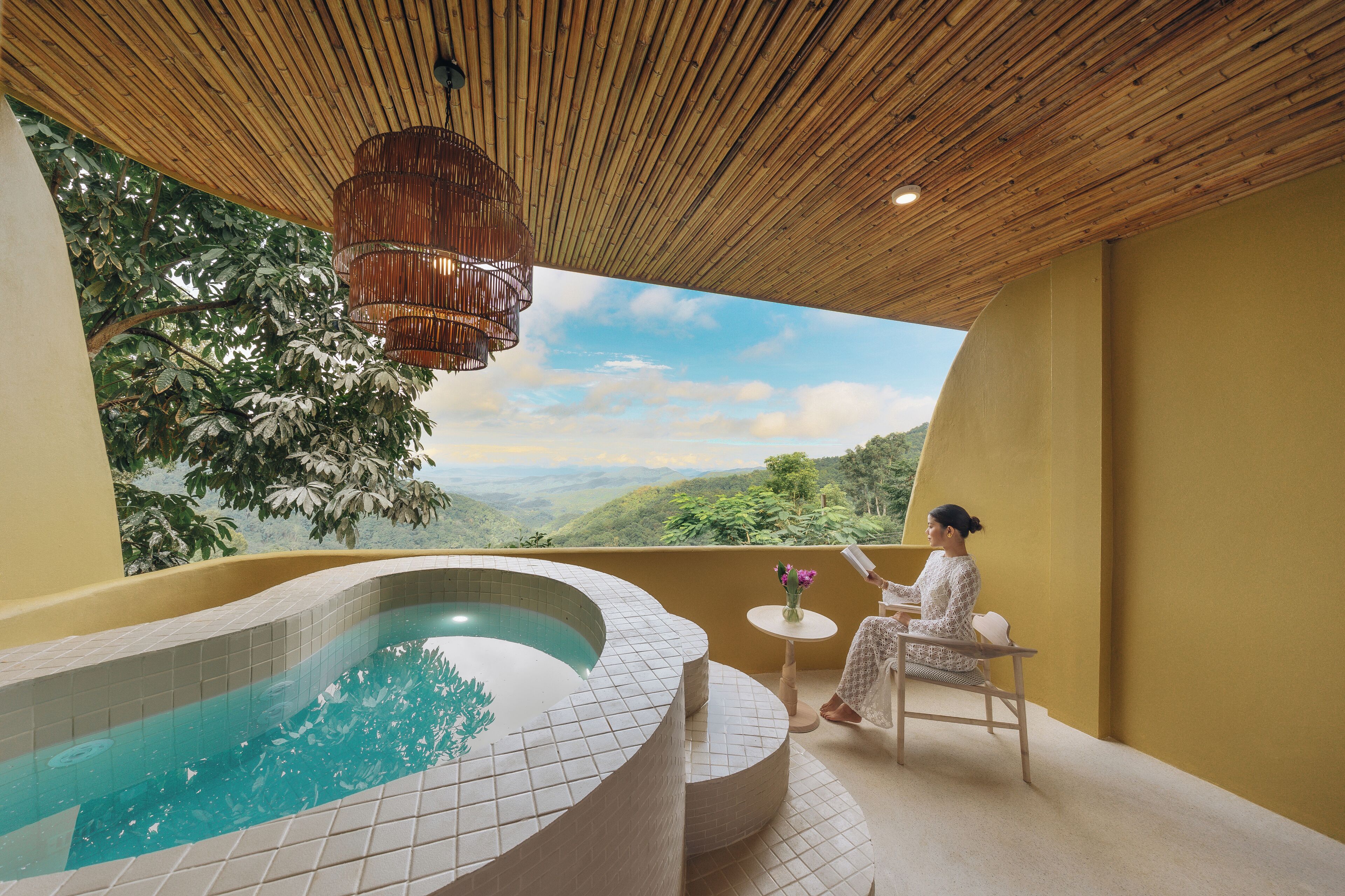 A spa area with a hot tub, a wooden ceiling, and a view of a mountainous landscape.