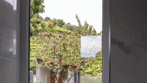 A bathroom with a view of a stone wall and a grassy area outside. - Luxury Douro Villa with Pool & Panoramic Views (Ferreiros de Avões)