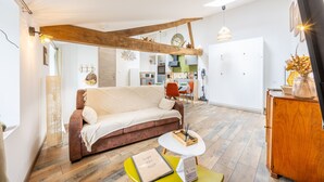 Ein modernes Wohnzimmer mit einer Couch, einem kleinen runden Tisch und einem Holzschrank.