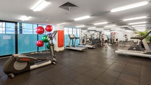 Een sportschool met loopbanden, elliptische trainers en fitnessballen.