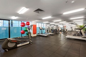 Een sportschool met loopbanden, elliptische trainers en fitnessballen.