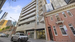 A modern building with a glass facade and a brick entrance.