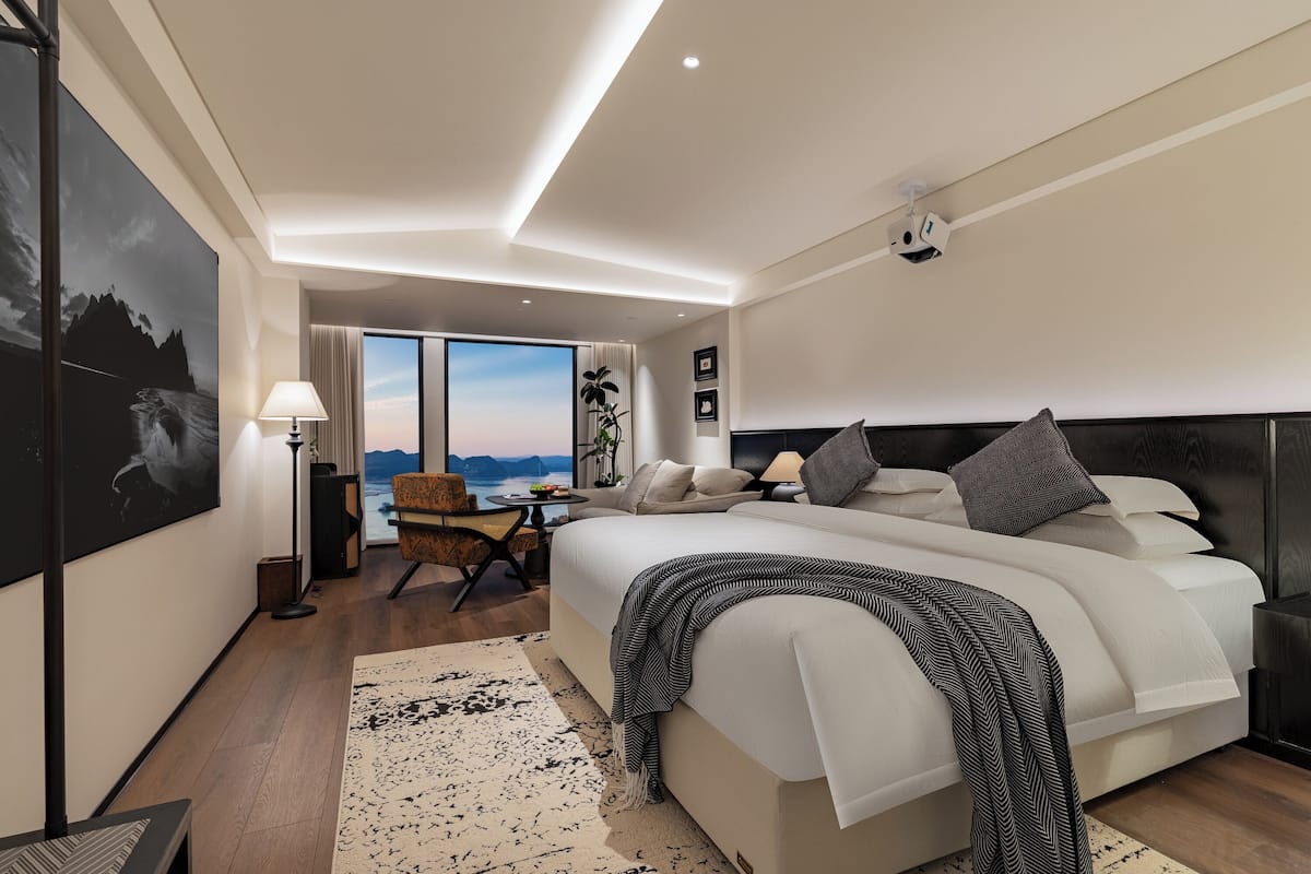Ein modernes Hotelzimmer mit einem großen Bett, einem Schreibtisch und Blick auf die Berge.