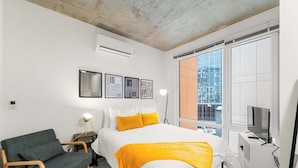 Une chambre à coucher moderne avec un lit, un canapé, un bureau et un téléviseur.