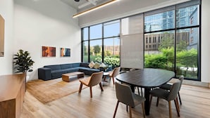 Un espace de bureau moderne doté d’une grande table de réunion, de sièges confortables et de larges fenêtres offrant une vue sur la ville.