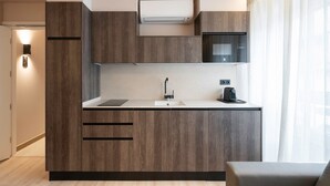 Una cocina moderna con armarios de madera, microondas integrado y cafetera.