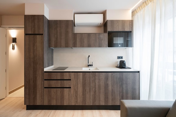 A modern kitchen with wooden cabinets, a built-in microwave, and a coffee maker.