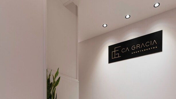 Una escalera con un letrero en la pared que dice 'ECA GRACIA APARTAMENTOS'.