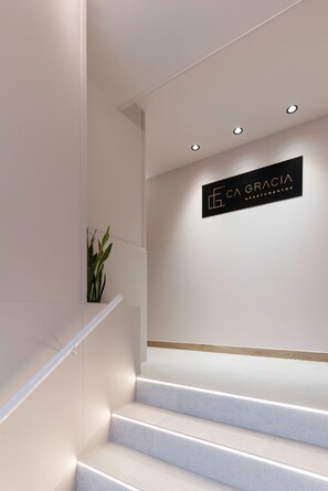 A staircase with a sign that reads 'ECA GRACIA APARTAMENTOS' on the wall.