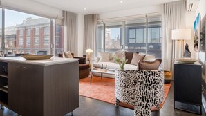 A modern living room with a sofa, coffee table, and a patterned side table.