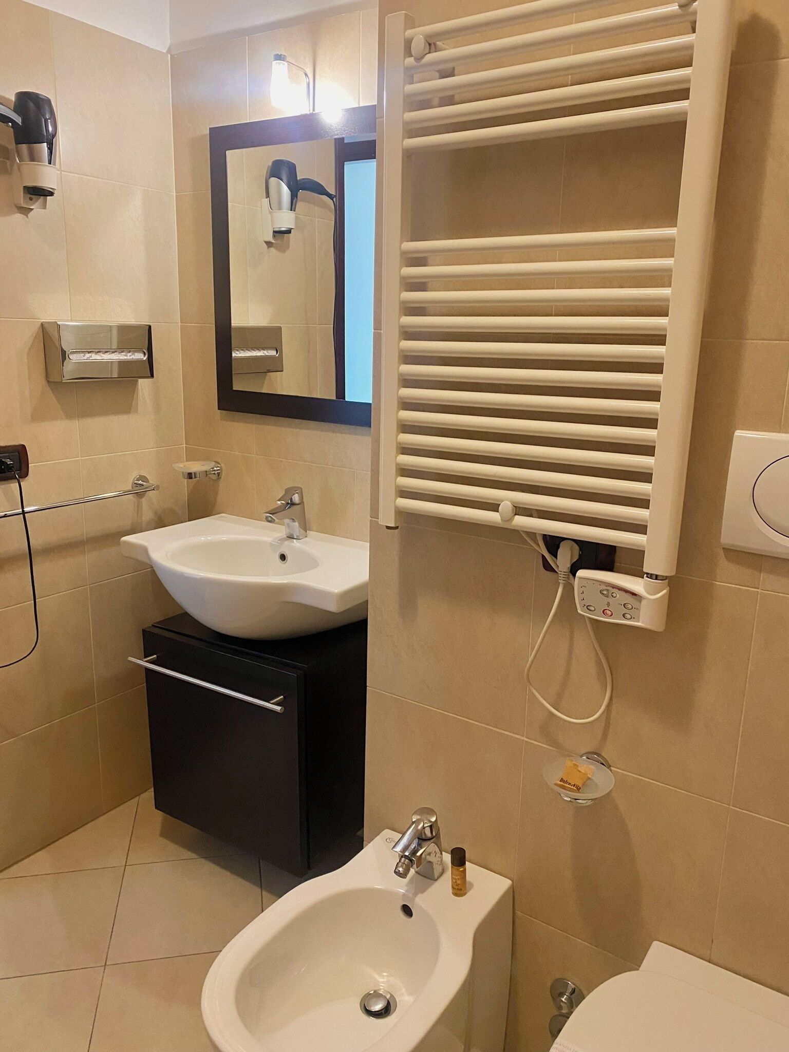 Une salle de bain moderne équipée d’un lavabo, d’un bidet et d’un sèche-serviettes.