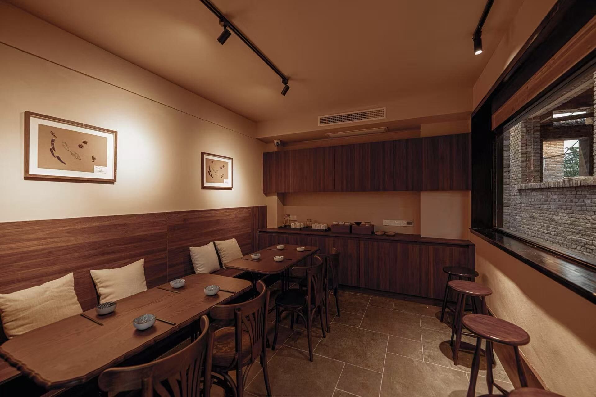 A restaurant with wooden furniture, a bar area, and framed artwork on the walls.