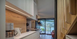 Una cocina moderna con cafetera, hervidor y horno empotrado.