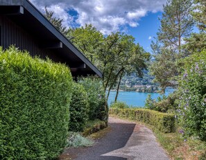 Un sendero que lleva a un edificio con vistas a un lago y montañas.
