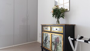 A room with a wardrobe, a cabinet with glass doors, and a mirror on the wall. - Italianway Comfort - Watt 8 (Milan)