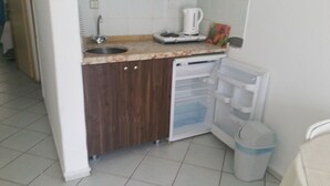 A compact kitchen with a sink, a coffee maker, and a refrigerator with a freezer drawer. - Özlem  1 Apart (Marmaris)