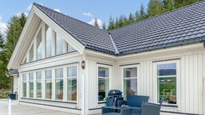 A modern house with large windows, a deck, and a barbecue grill. - 5 bedroom awesome home in Eidsvåg i Romsdal (Eidsvåg i Romsdal)