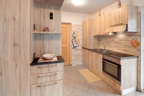 Une cuisine moderne avec des meubles en bois, un évier en acier inoxydable et un four encastré.