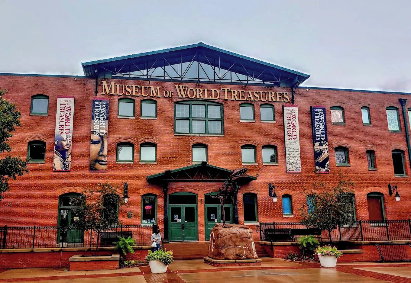 A brick building with the sign "Museum of World Treasures" and multiple banners.