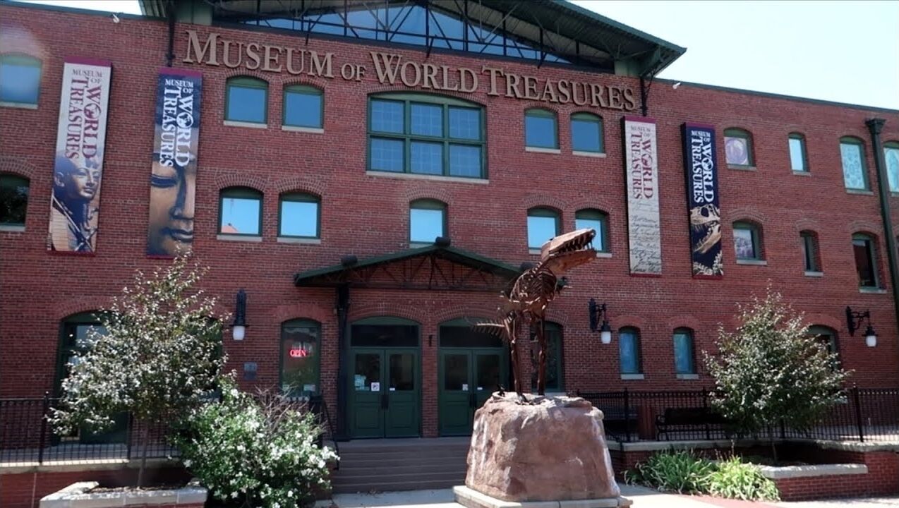 El exterior del Museo de Tesoros del Mundo, con fachada de ladrillo, grandes puertas de entrada y banderines.