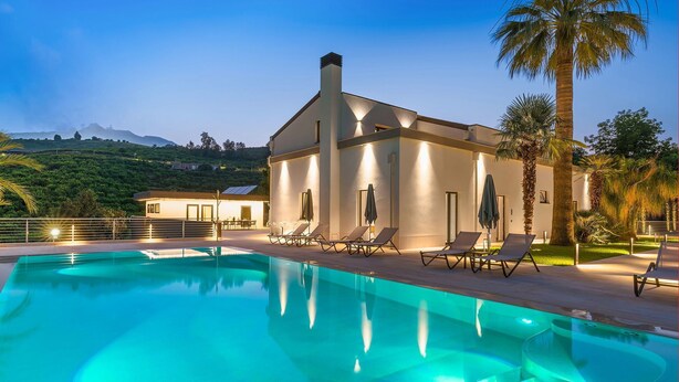 A modern villa with a swimming pool, lounge chairs, and a view of the hills. - Villa Cloris sea view and pool - My Rental Homes (Mascali)