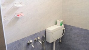 Een kleine badkamer met toilet, bidet en wastafel.