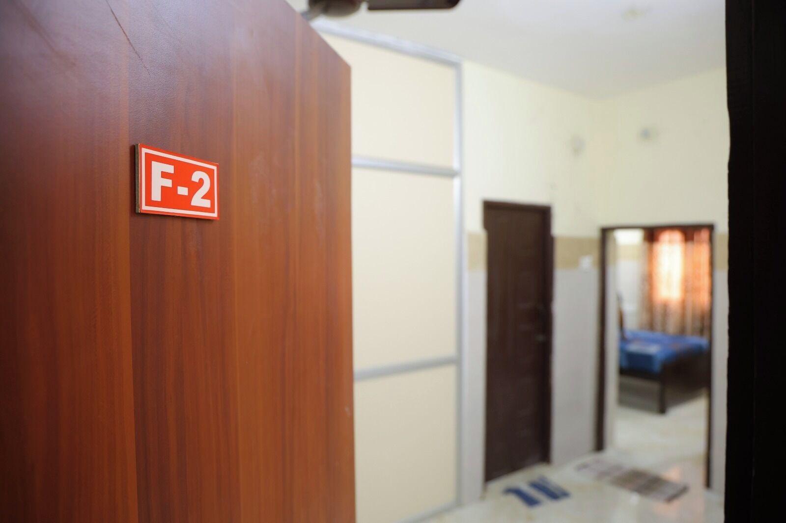 A hotel room with a wooden door marked "F-2".
