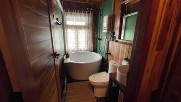 Un baño pequeño con bañera, inodoro y lavamanos.