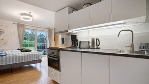 A modern kitchen with a built-in oven, a coffee maker, and a sink.