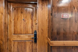 Une porte en bois avec une poignée en laiton et une plaque en laiton portant le numéro 414.