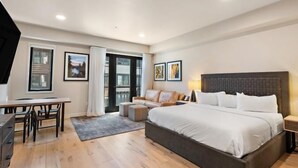 Quarto moderno com uma cama grande, uma escrivaninha e um sofá.