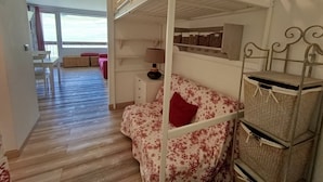 Una habitación con literas, un escritorio, una silla y una ventana.