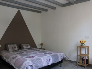 A bedroom with a bed, a nightstand, a lamp, and a wooden bookshelf. - Rural charm between Le Mans and Tours, renovated house in nature (Flée)