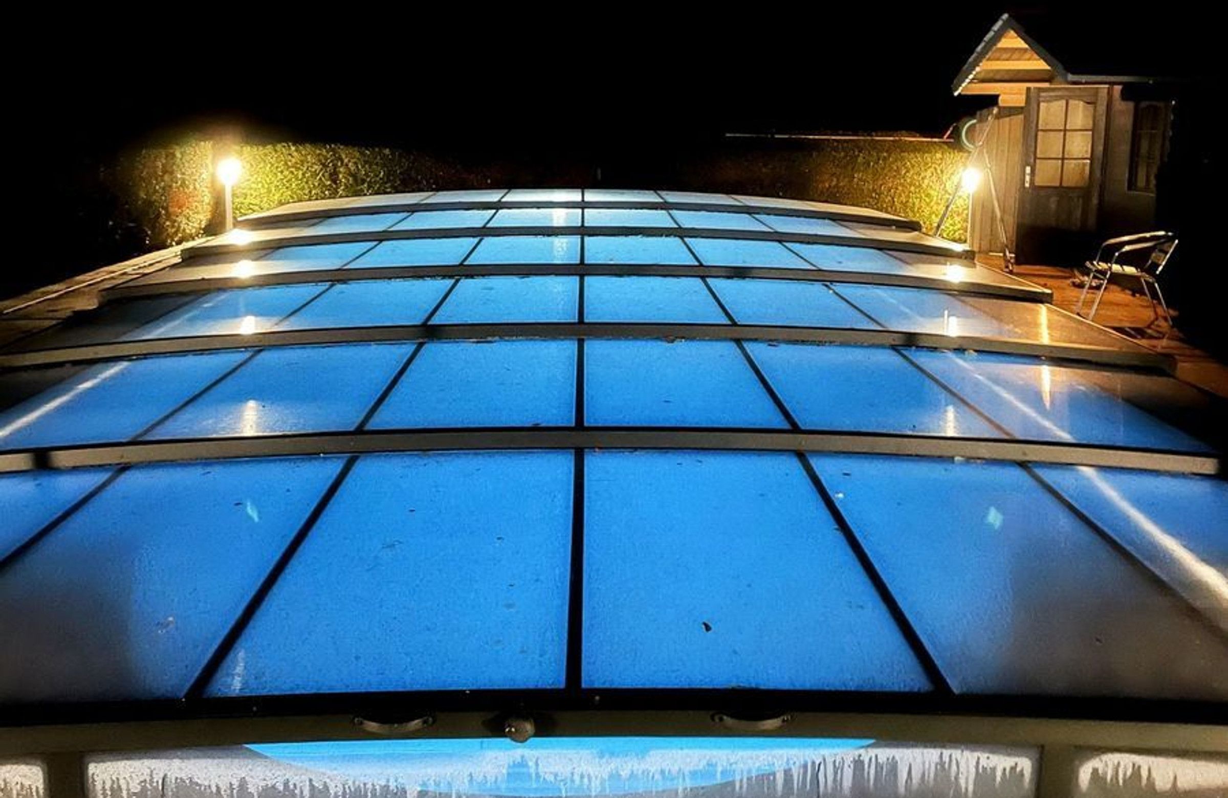 Eine große, gewölbte Glasdachkonstruktion mit Rastermuster, vermutlich Teil der Architektur eines Gebäudes.