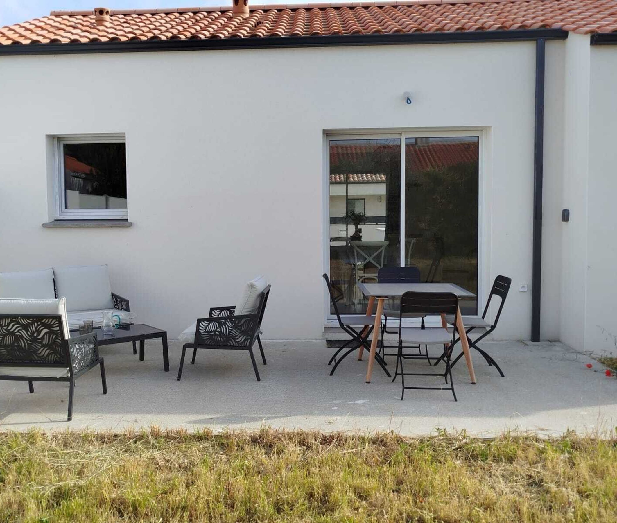 A patio with outdoor furniture, a window, and a sliding glass door.