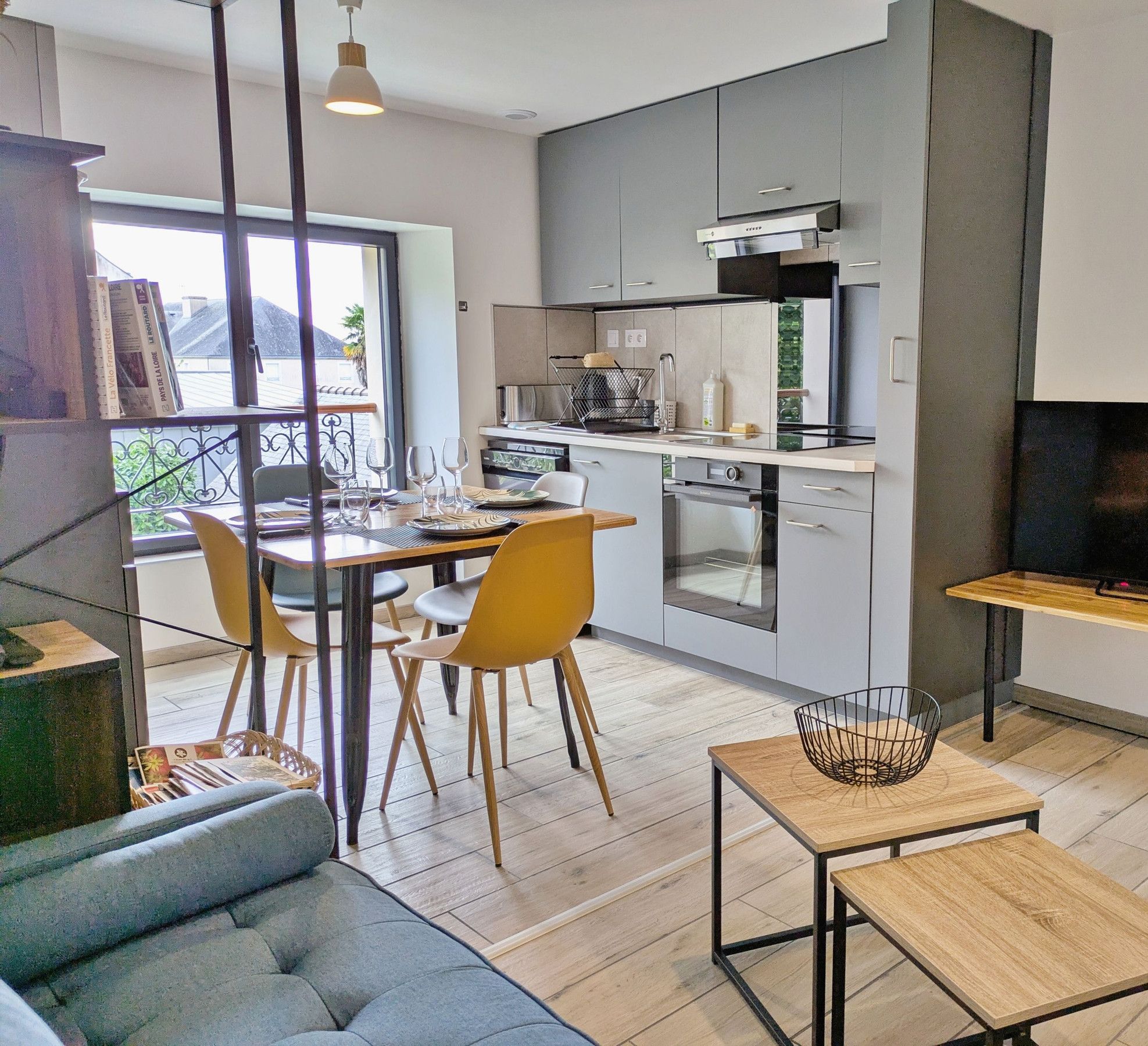 A modern apartment with a dining area, kitchen, and living room.