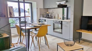 A modern apartment with a dining area, kitchen, and living room.