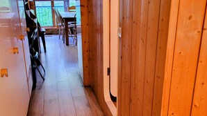 A wooden interior hallway with a dining area visible in the background. - Apartment 5 pers, Bright, Wifi, Pets allowed (Les Arcs 1800)