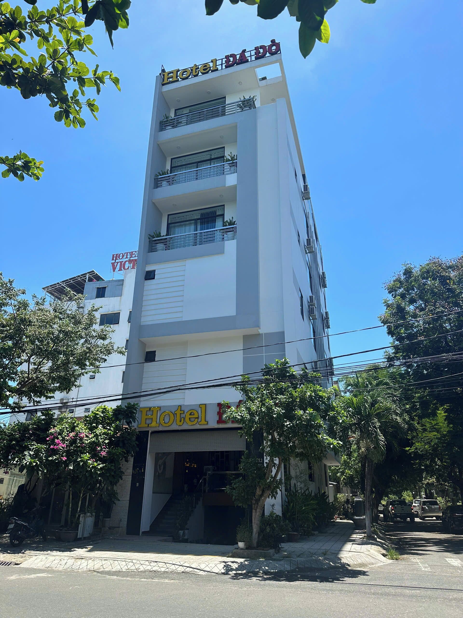 A multi-story hotel building with balconies and a sign reading "Hotel DA DO".
