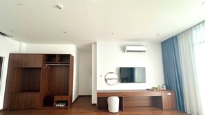 Ein modernes Zimmer mit einem Holzschrank, einem Flachbildfernseher und einer Klimaanlage.