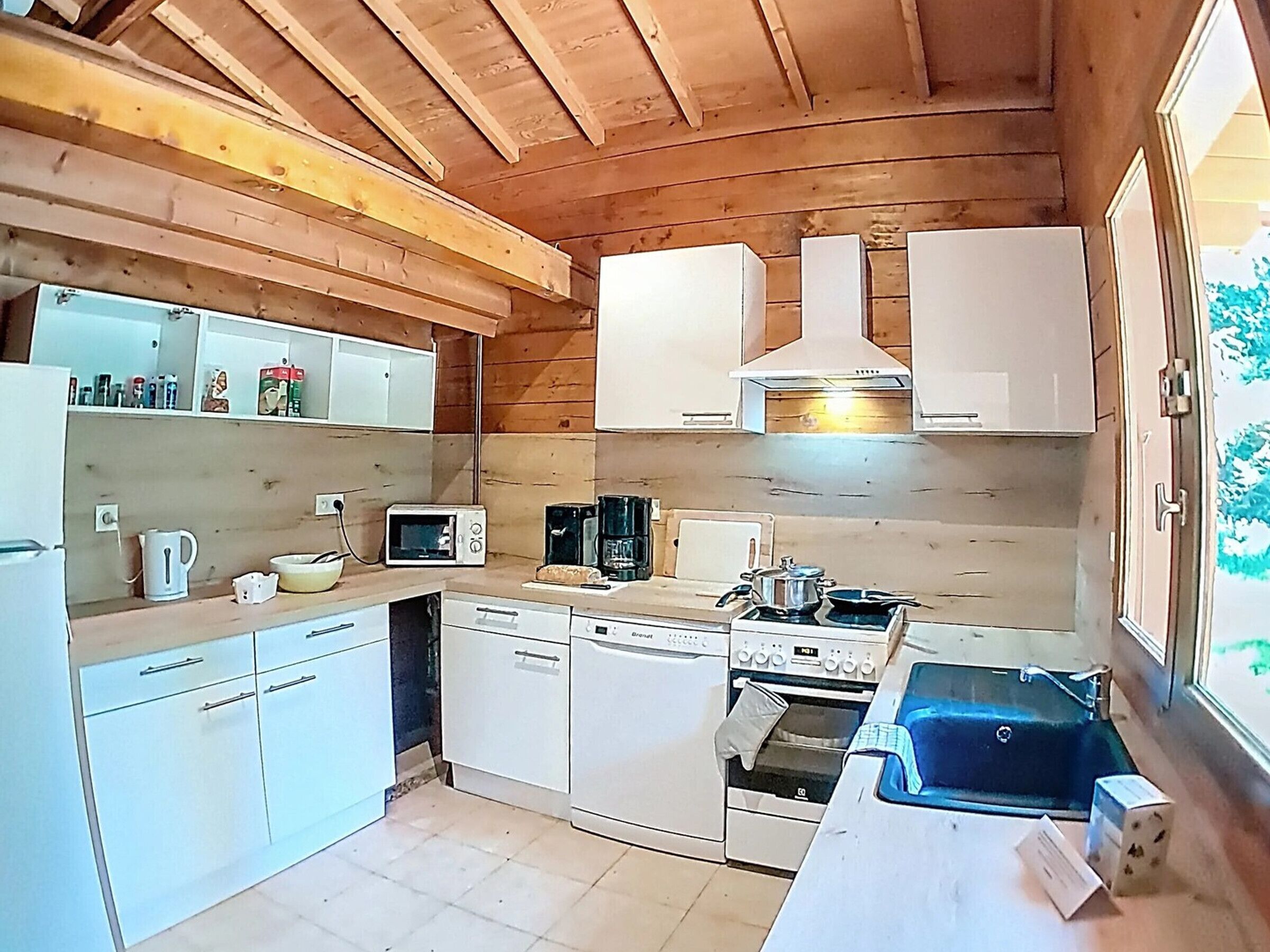 A compact kitchen with white cabinets, a microwave, a stove, and a dishwasher.