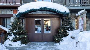 A snow-covered entrance to a building with two Christmas trees and a sign indicating a residence for tourism. - Arc 1950 - 3-Room Apartment, 67sqm, 6 pax (Les Arcs 1950)