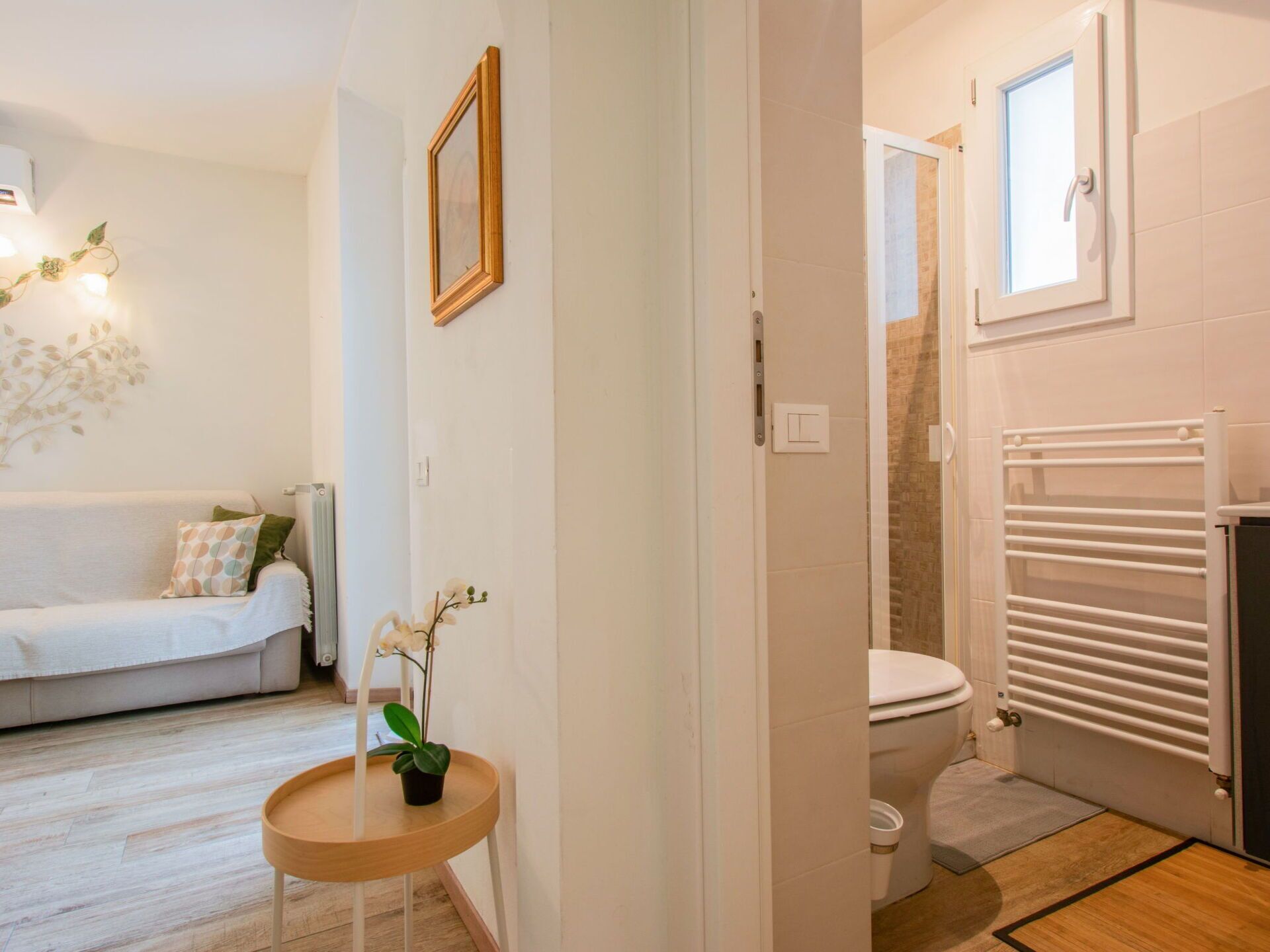 Une salle de bain moderne équipée de toilettes, d’une douche et d’une porte en verre donnant accès à l’espace douche.