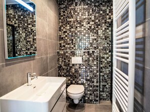A modern bathroom with a rectangular sink, a toilet, and a shower area. - Stunning private villa for 10 guests with WIFI, pool, TV and terrace (Apeldoorn)