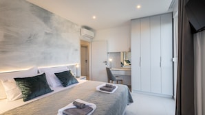 Une chambre moderne avec un grand lit, un bureau et une armoire.
