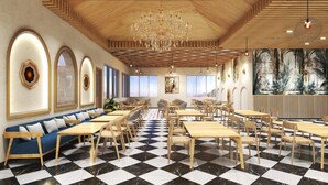 A restaurant with a checkered floor, wooden tables and chairs, a blue sofa, and a chandelier. - The Orchid Rishivan Rishikesh (Rishikesh)