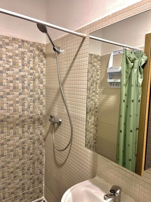 Chuveiro, toalhas de banho, sabonete, papel higiênico