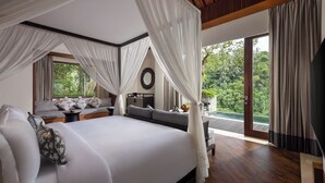 Un dormitorio espacioso con una cama grande, vistas a exuberante vegetación y un balcón.