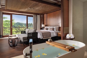 A hotel room with a large bed, a sitting area, a bathtub with flowers, and a view of the outdoors. - Impiana Private Villas Ubud (Ubud)