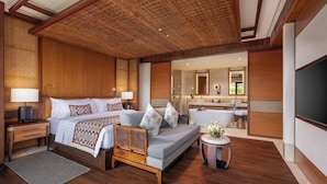 A modern hotel room with a large bed, a sitting area, a bathroom with a bathtub, and a TV. - Impiana Private Villas Ubud (Ubud)